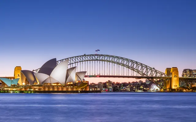 The Sydney Opera House and Harbour Bridge at dusk, seen across Sydney Harbour