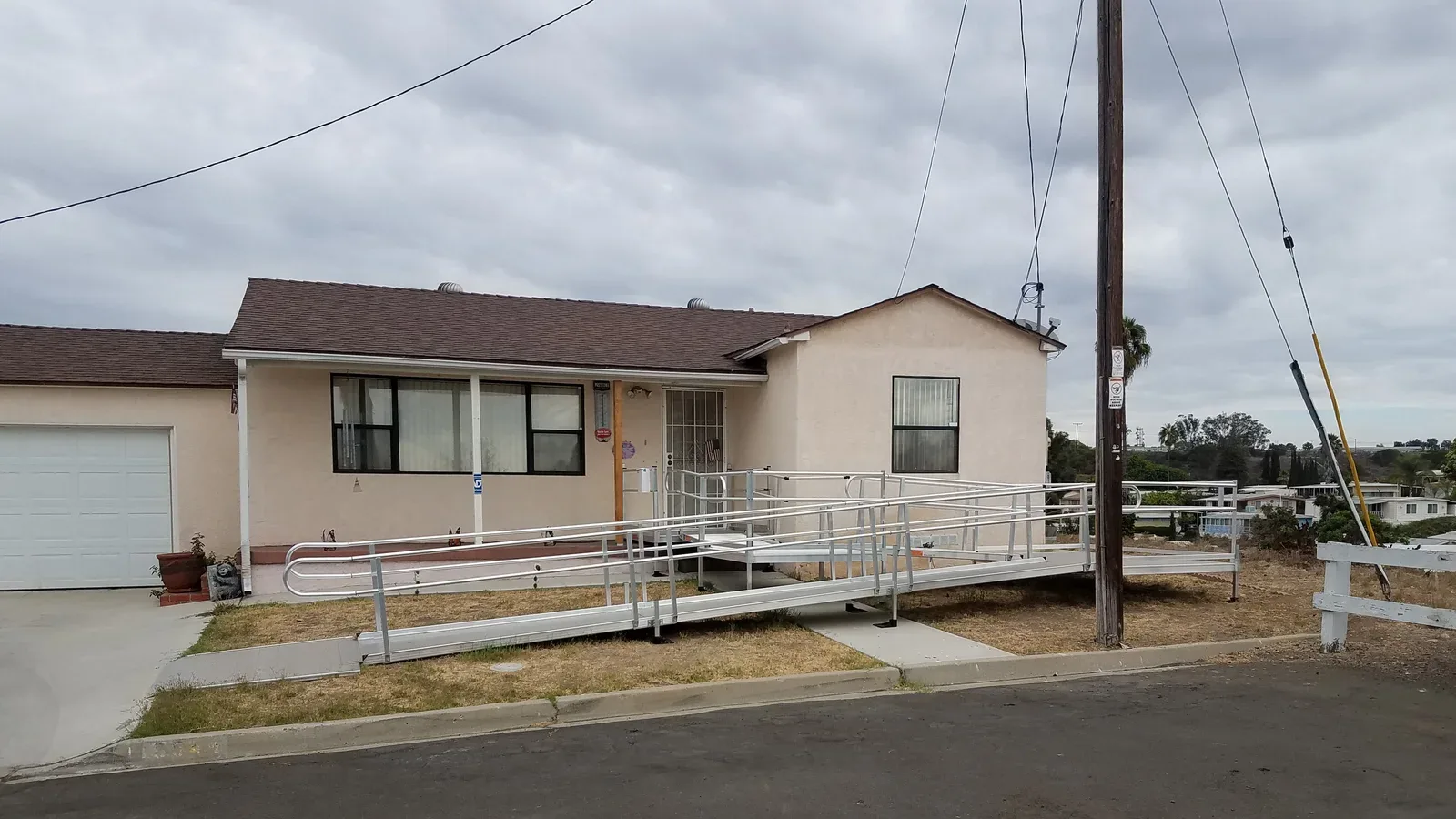 Wooden residential accessibility ramp leading up to the front entrance of a modest single-family house