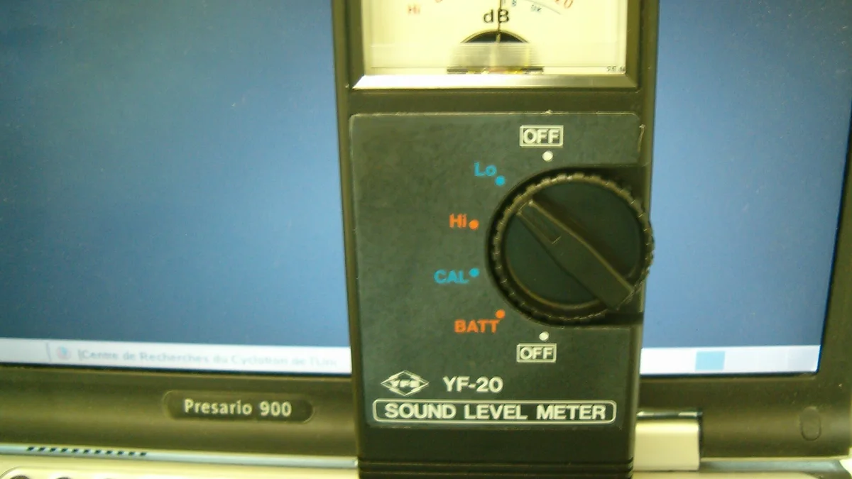 A handheld sound level meter displaying a decibel reading