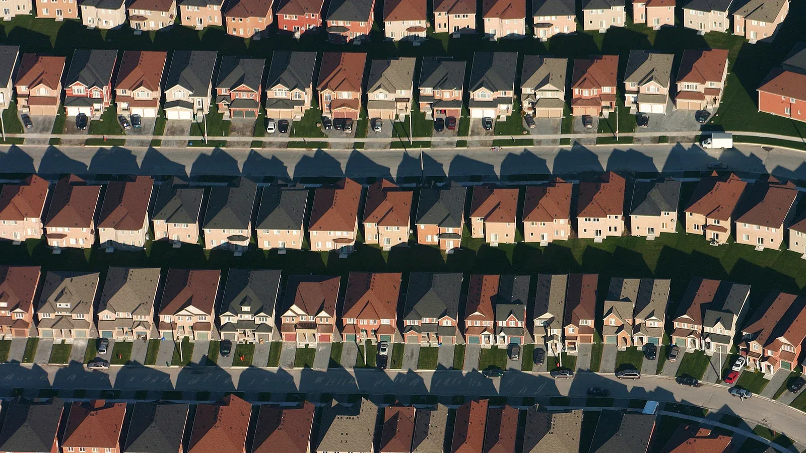 Aerial view of dense suburban rooftops and tree-lined residential streets