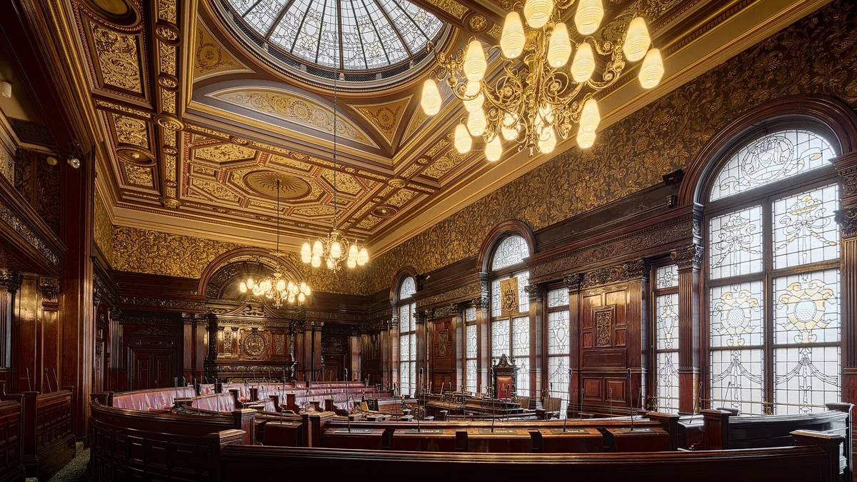 The council chamber at Glasgow City Chambers, with curved rows of desks beneath a glass dome