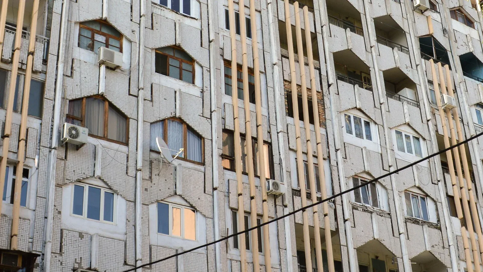 A multi-story apartment building facade with rows of balconies