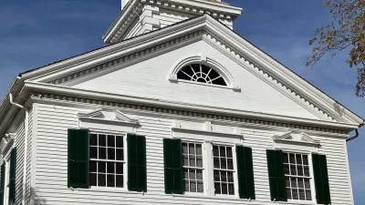 A white early Victorian building with green shutters in Cape May Court House, New Jersey