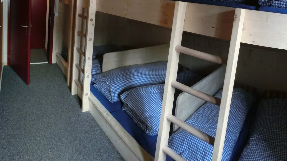 A bunk-bed room with neatly made-up bunks