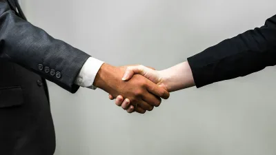 Two people in suits shaking hands