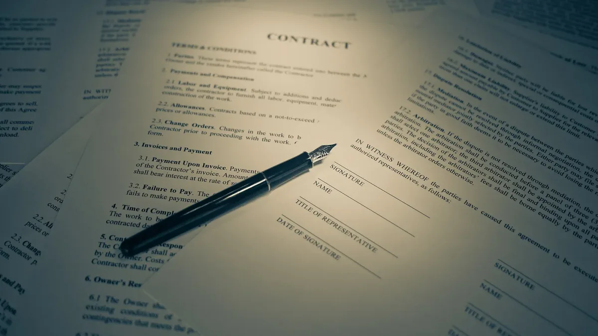 A printed contract with a pen resting on it