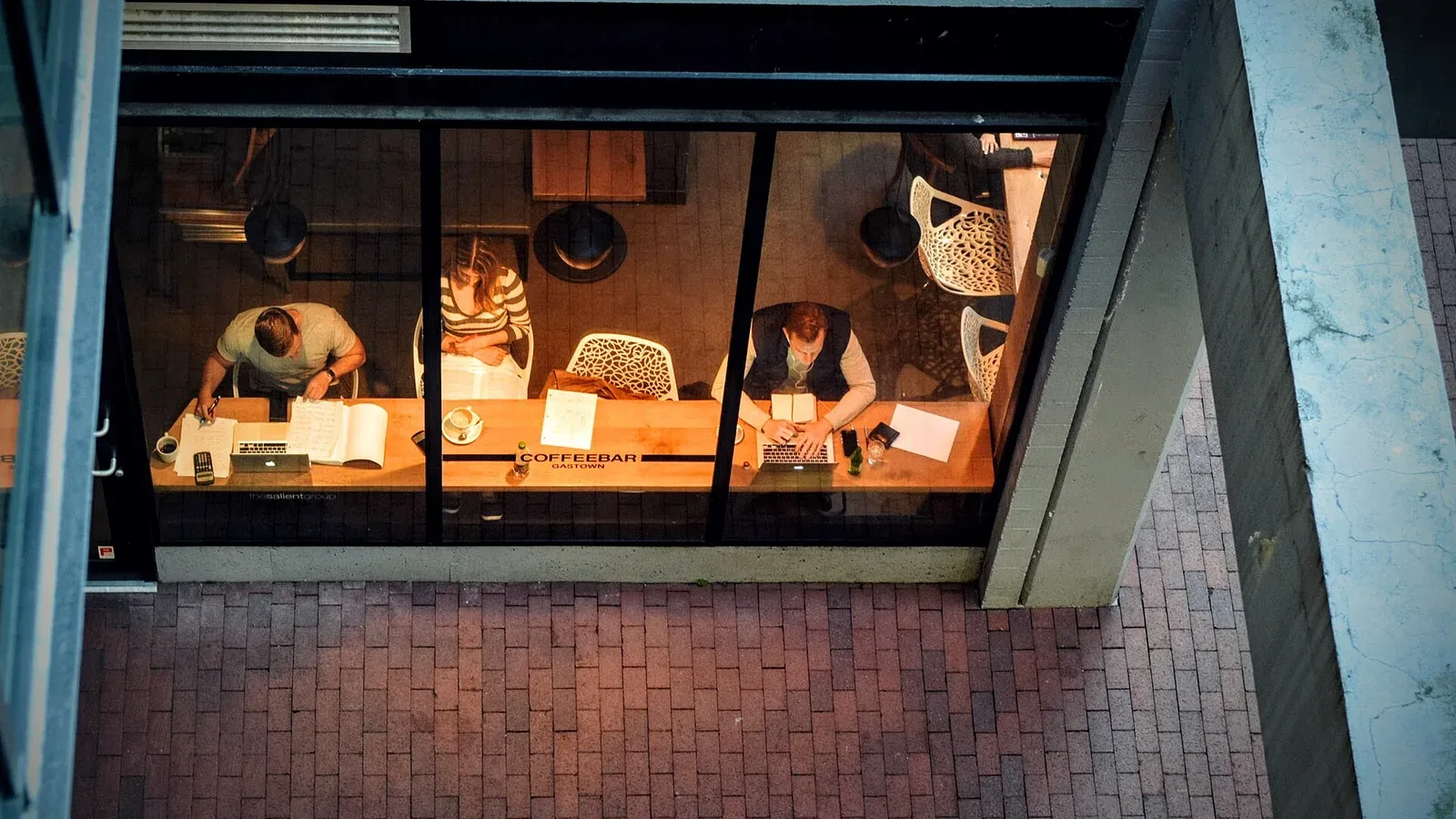 People working on laptops at a busy coffee shop