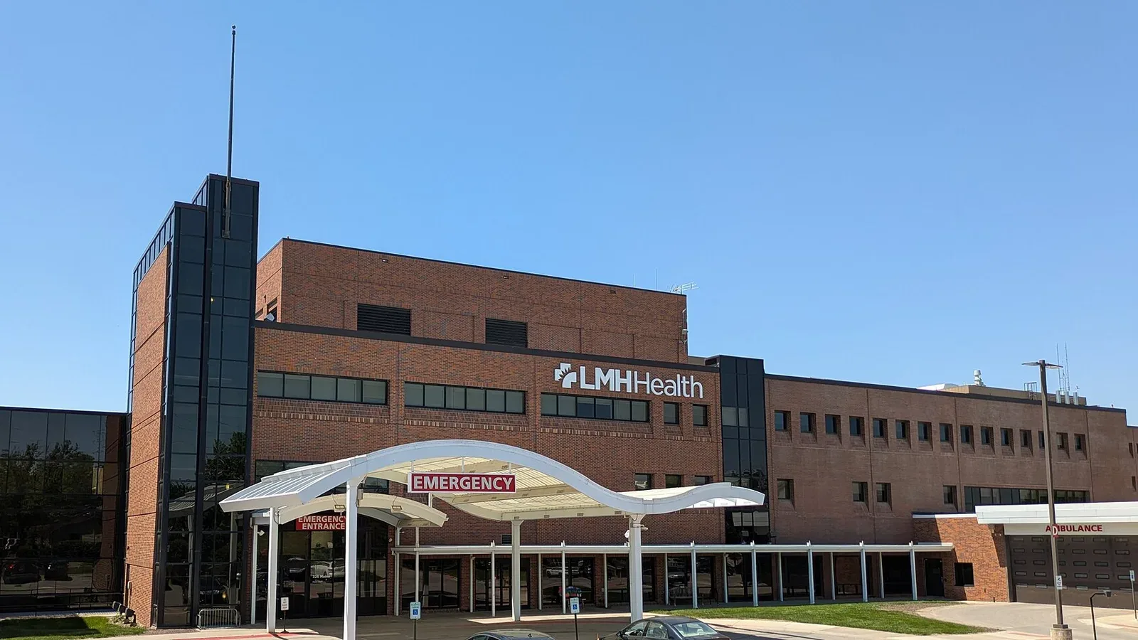 The emergency entrance of a hospital with red signage over the doors