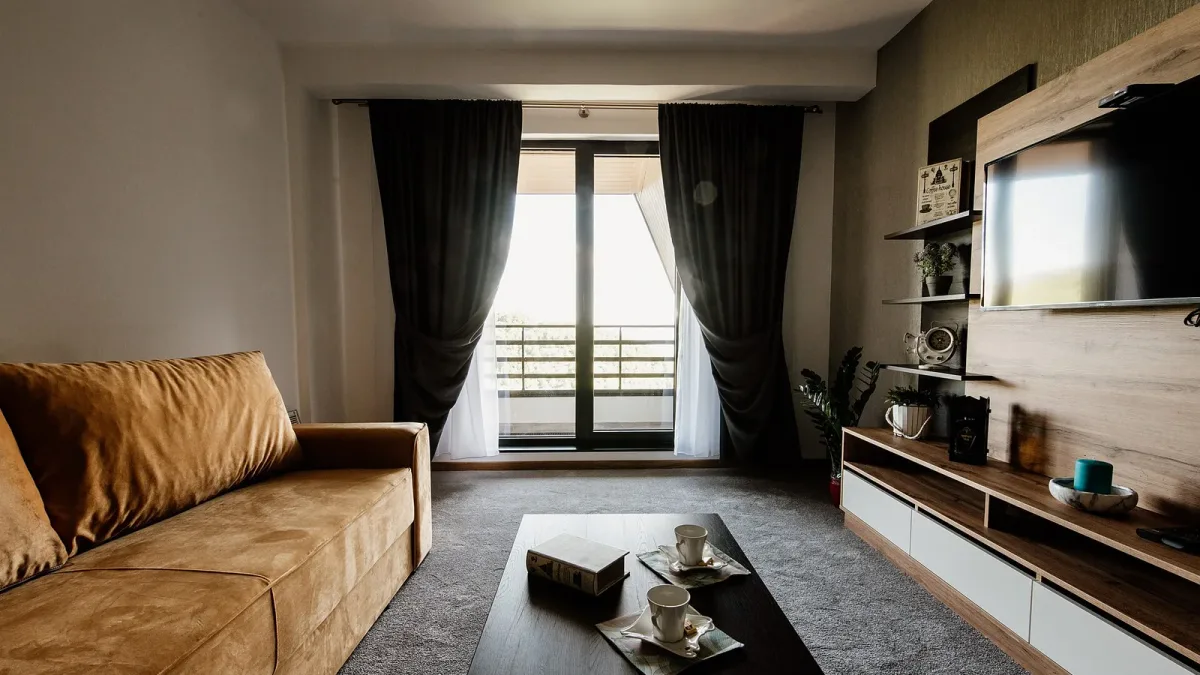 A modern furnished living room with stylish furniture and a view of the outdoors