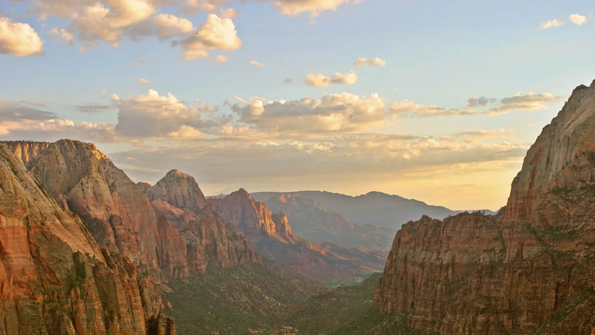 View down Zion Canyon from the Angels Landing trail, with the Virgin River and canyon road winding far below between sheer red sandstone walls