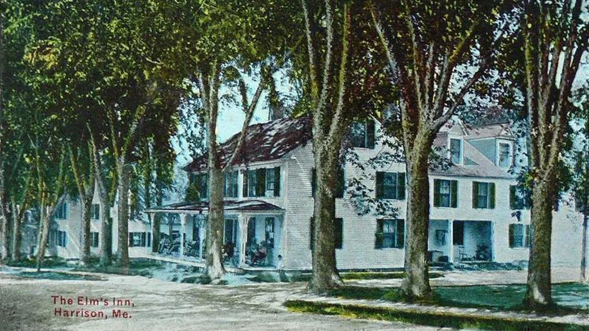 A small inn building with a wide porch in Harrison, Maine