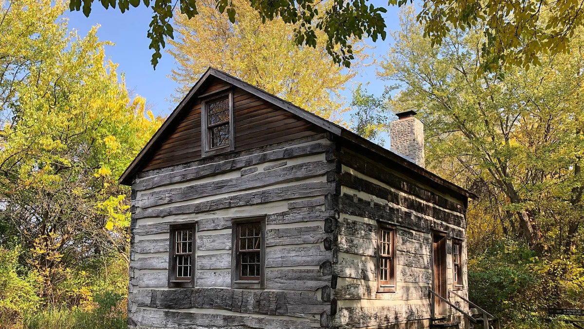 A log cabin surrounded by autumn woods
