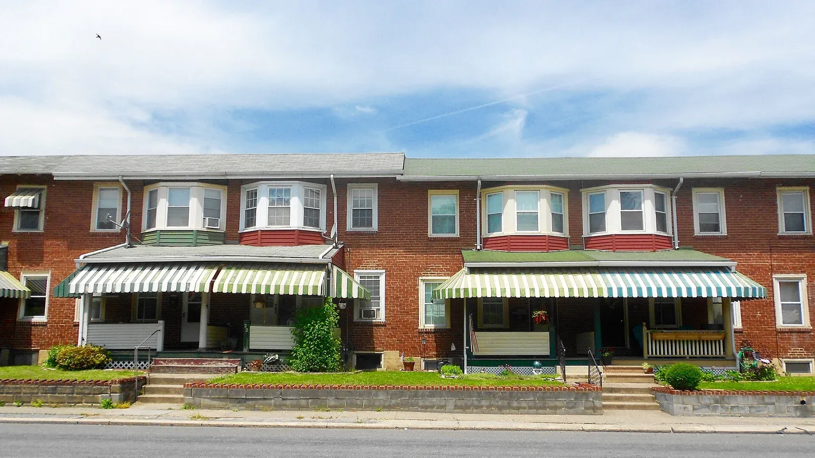 A row of near-identical brick townhouses with matching awnings