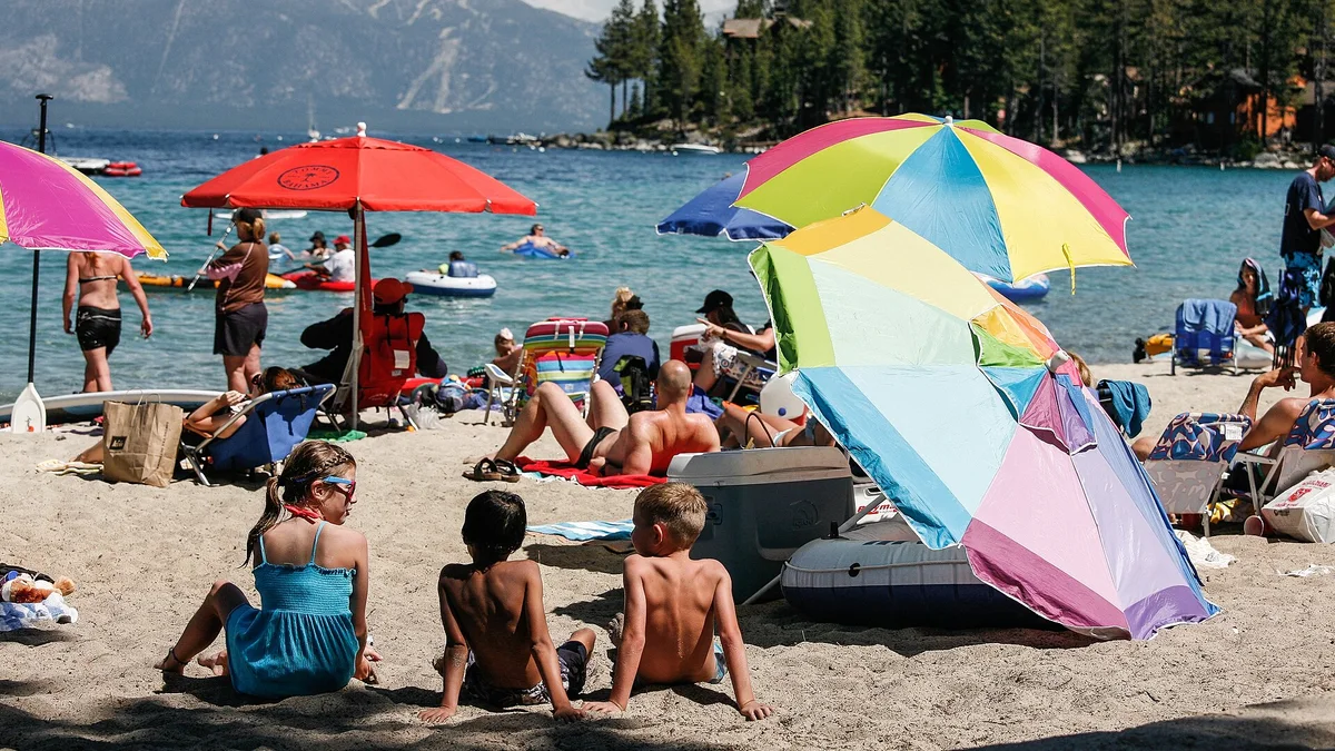 A crowded US lake beach in July — peak-season demand extends well beyond the coasts