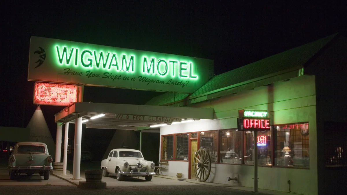 The neon sign of the Wigwam Motel on Route 66 in Holbrook, Arizona, lit at night