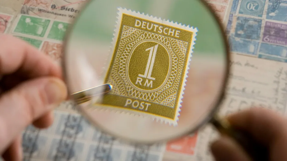 A magnifying glass held over a postage stamp