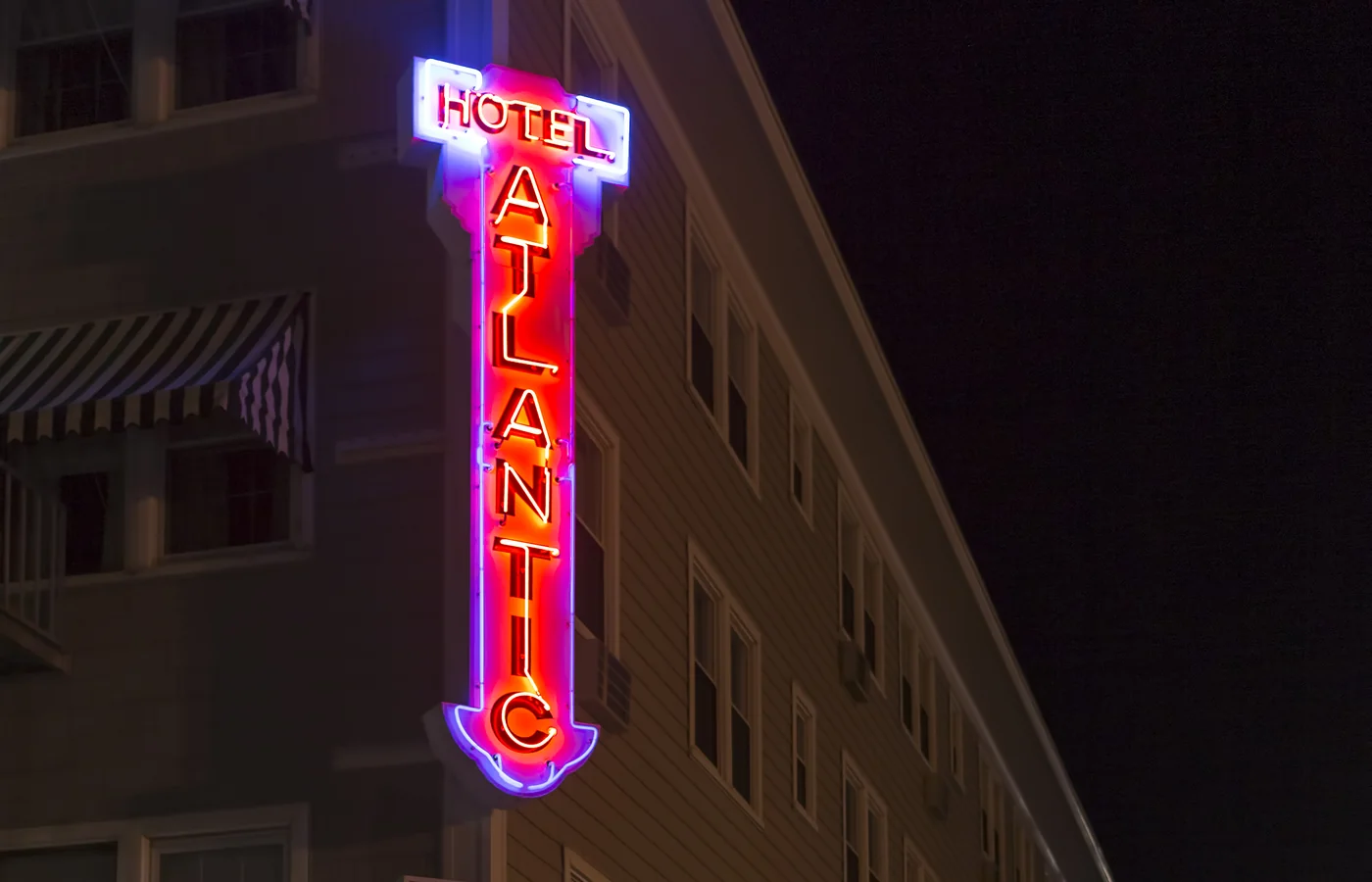 The neon sign of the Atlantic Hotel at night on the boardwalk in Ocean City, Maryland