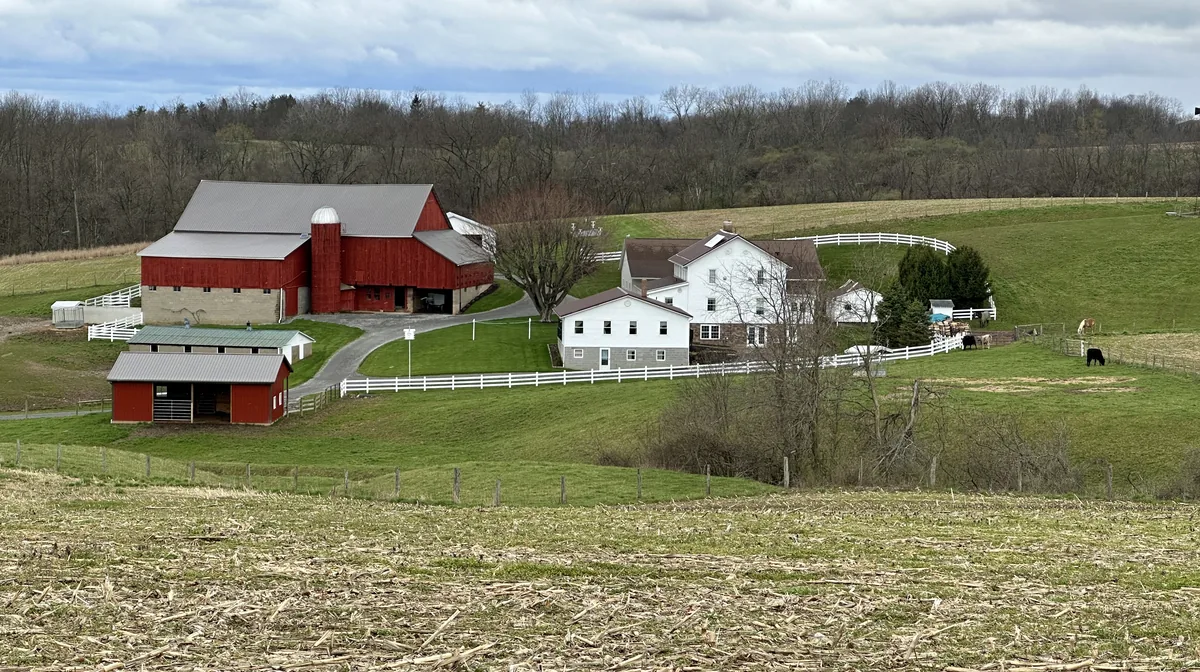 An Amish farm with red barns and a white farmhouse in Holmes County, Ohio
