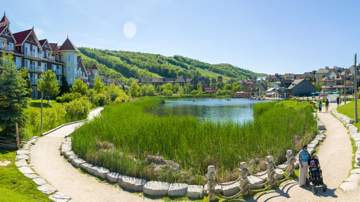 Blue Mountain Village and its Mill Pond in summer, with the ski runs of Blue Mountain behind, Ontario