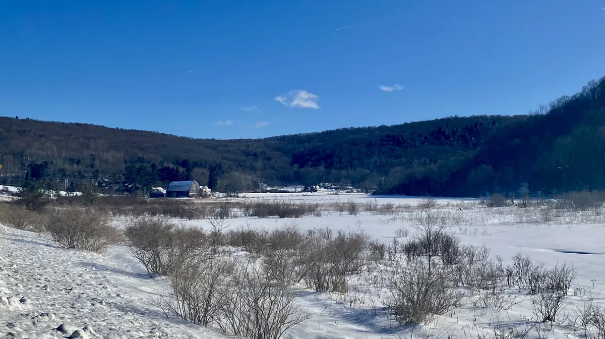 Snow across a valley below wooded hills in the town of Ellicottville, New York, in February