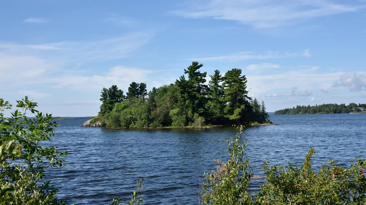A small pine-covered island on Lake of the Woods near Kenora, Ontario, on a summer afternoon
