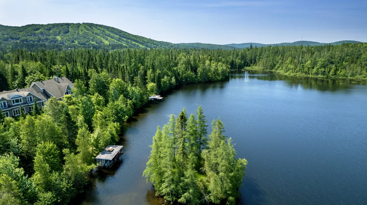 Lac Neigette in Lac-Beauport, Quebec, from the air, with ski runs on the hill behind the forest