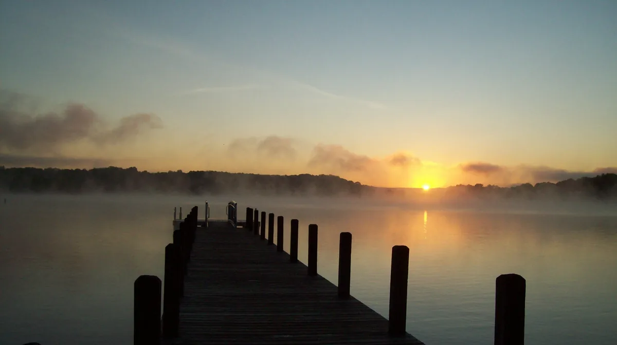 A dock running out into the morning mist at sunrise on Tims Ford Lake, Tennessee