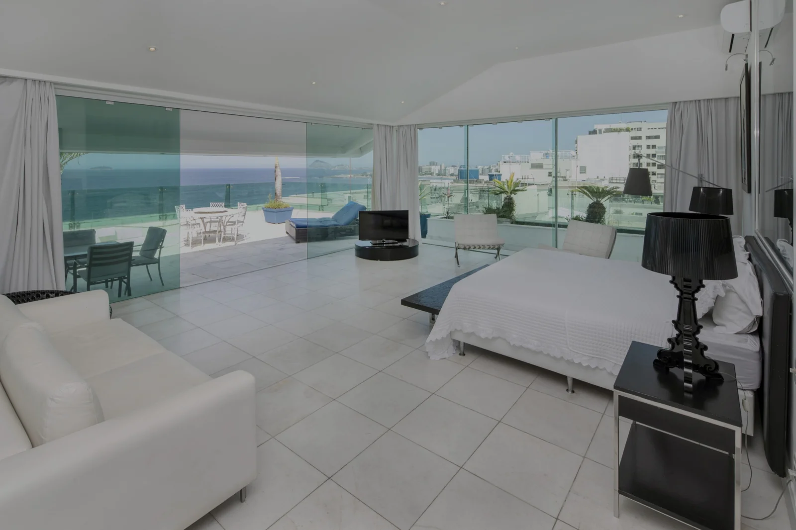 Copacabana penthouse bedroom before Cavmir interior redesign — bare tiled floor, minimal styling, harsh midday light